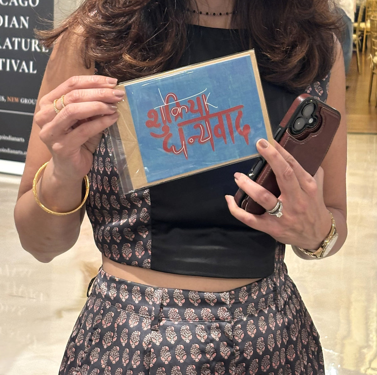 Hands holding the Shukriya Dhanyavad thank you card at the Chicago Indian Literature Festival.