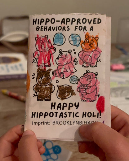 Hippo-Approved Holi mini zine cover, colored in, held by a child