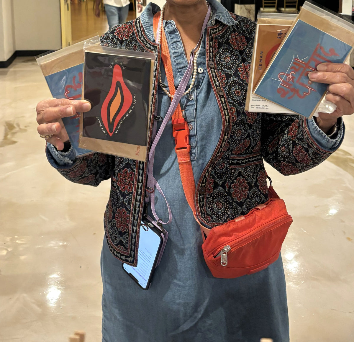 Hands holding the You Are the Diya Shubh Diwali card and other Type Storytelling cards at the Chicago Indian Literature Festival.