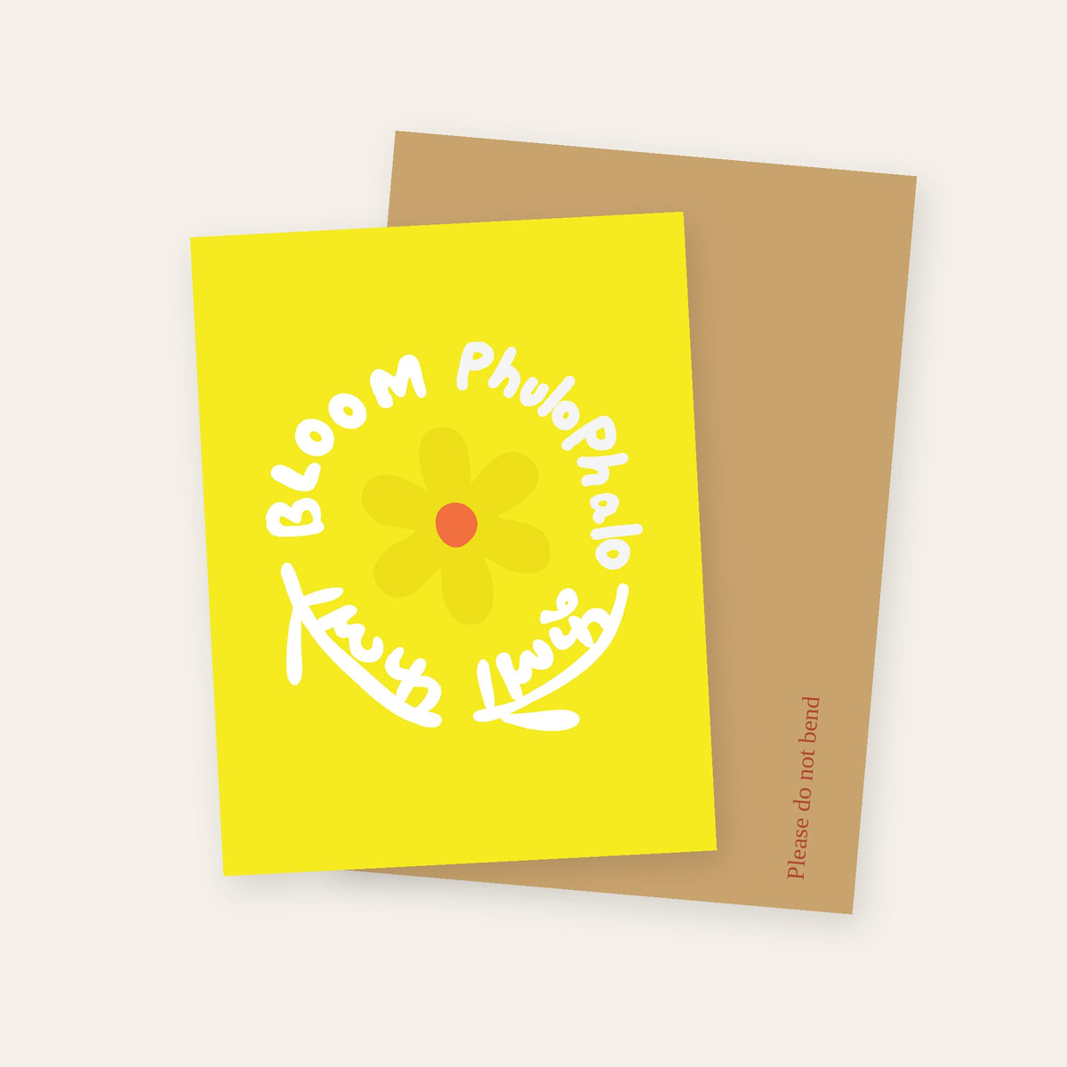 Flower Bloom greeting card in yellow, with Bloom and Phulo Phalo lettered in English and Devanagari around a flower, with its kraft mailer.