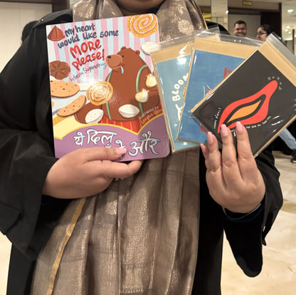 Hands holding Type Storytelling greeting cards and a BROOKLYNBIHARN book at the Chicago Indian Literature Festival.