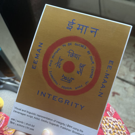 Hand holding the Integrity Eeman art print notecard, showing the language note under the art.