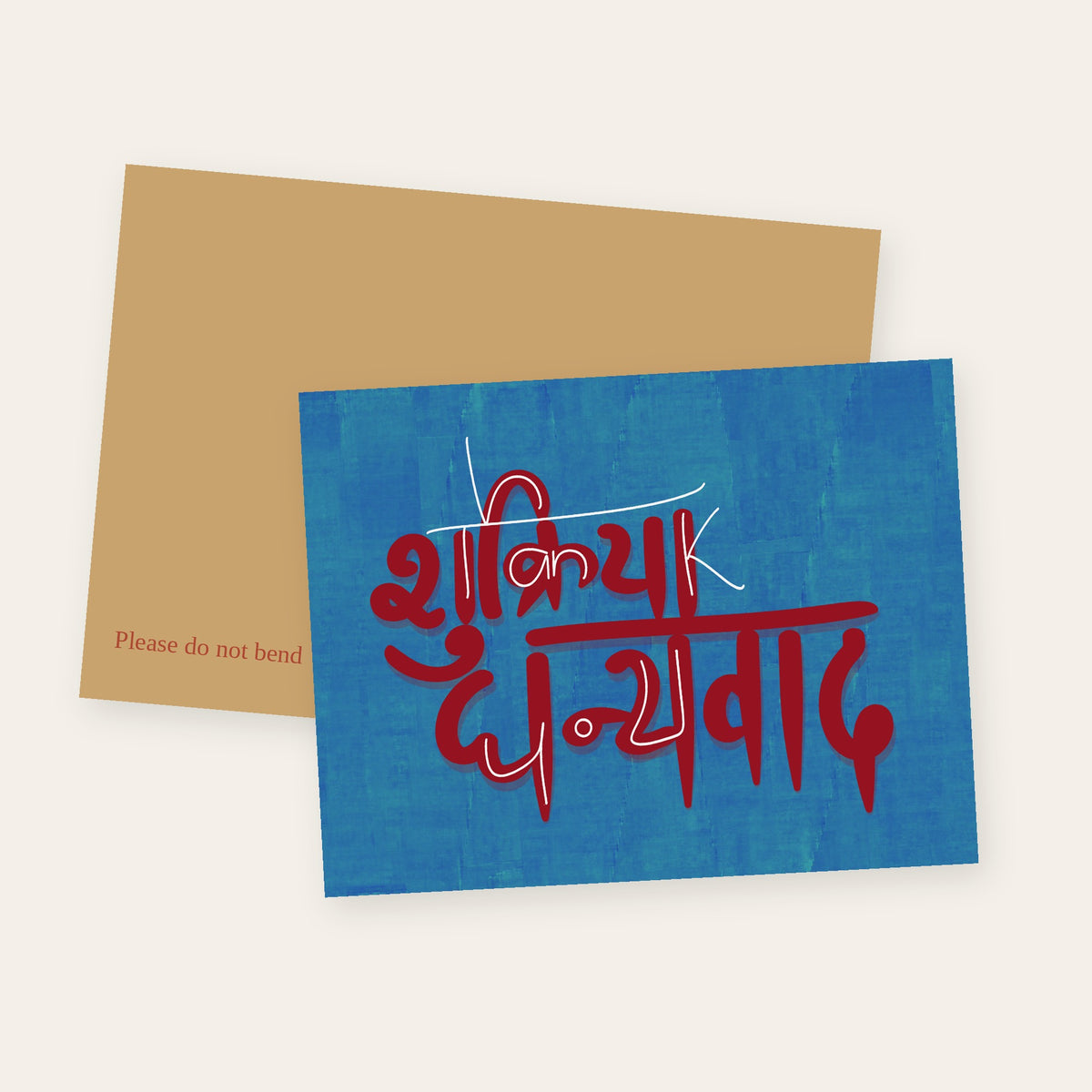 Shukriya Dhanyavad thank you greeting card with red Devanagari lettering on blue, shown with its kraft mailer.